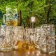 Stack of nearly empty beer steins in leafy beer garden